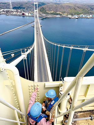 写真：主塔頂上からの眺めを堪能する参加者ら