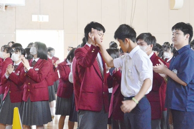写真：○×クイズで正解しハイタッチする両校の生徒