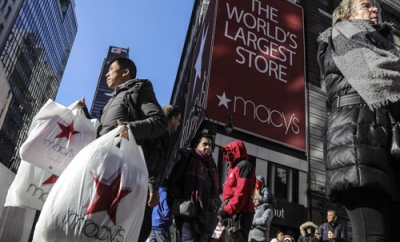 写真：ブラックフライデーセール中の米百貨店大手メーシーズの袋を提げ、店を出る買い物客＝２０１９年１１月２９日、ニューヨーク（ＡＰ＝共同）