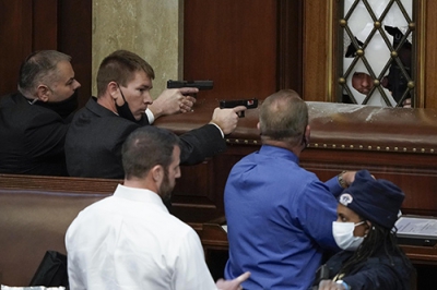 写真：６日、米ワシントンの連邦議会議事堂内で、銃を構えて警戒する警察官（ＡＰ＝共同）