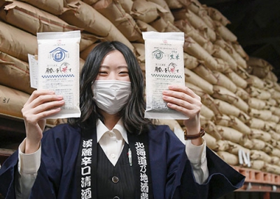 写真：高砂酒造が販売する料理用に転用した酒米。後方は酒米を入れ積み上げられた袋＝２０２１年１２月、旭川市
