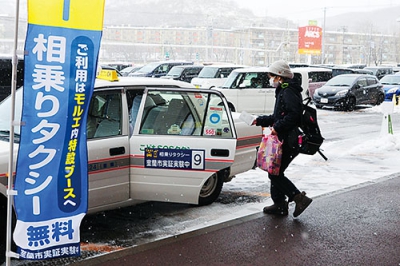 写真：買い物後、乗り合いタクシーに乗り込む利用者＝１７日午前１１時
