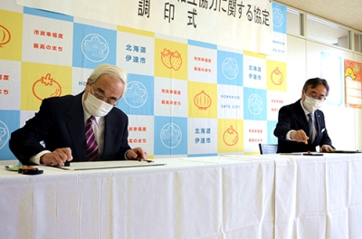 写真：協定書に署名する菊谷市長（左）と水野支店長