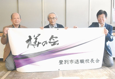 写真：写真上は新たに作った会旗を手にする（左から）吉野さん、加藤会長、中西さん。写真下は創立２０周年を記念して作った記念誌とＤＶＤ