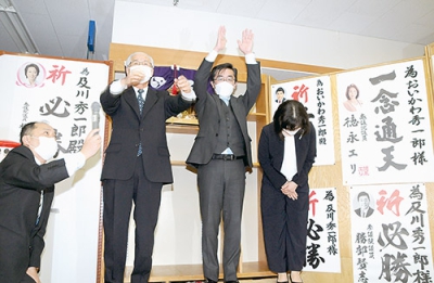 写真：再選を果たし、バンザイする及川町長（右から２人目）