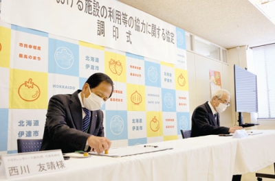 写真：協定を締結した右から菊谷市長と西川社長