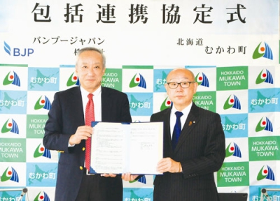 写真：協定書を手にする竹中町長（右）と井土社長