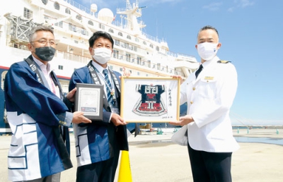 写真：福元ゼネラルマネージャーに寄港の記念品を手渡す戸田町長（左から２人目）