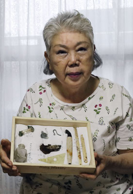 写真：爆心地付近で収集した遺品を手にする竹下芙美さん＝６月５日、長崎市