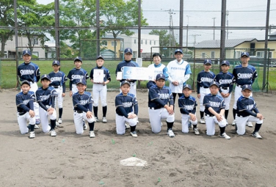 写真：白老町少年野球クラブメンバーと記念写真に収まるしらおい後援会の村上会長（奥側右から５人目）