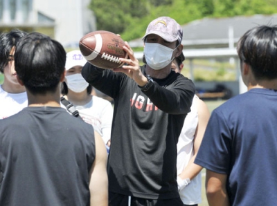 写真：選手たちに捕球技術を教える同大の橋詰ヘッドコーチ＝京都府京田辺市