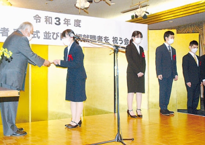 写真：新規就職者に記念品を贈る早坂会長（左）