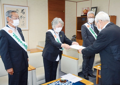 写真：菊谷市長に首相メッセージを伝達する早坂会長（正面左から２人目）