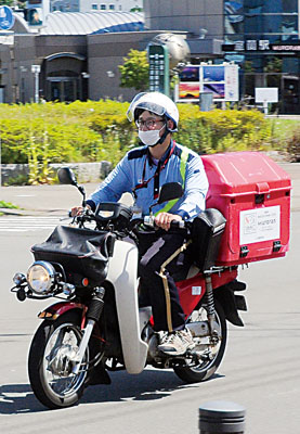 写真：ステッカーを掲示し市内を走る室蘭郵便局のバイク
