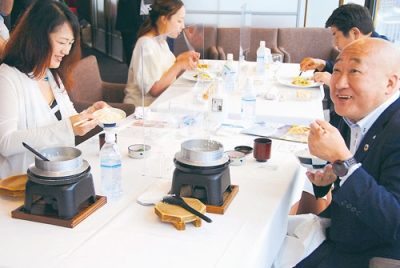 写真：財田米の釜焚きご飯を一口食べて「甘くてうまい」と笑みがこぼれる下道町長（右）