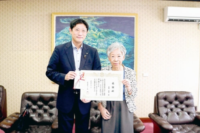写真：「記念事業に活用して」と寄付金を手渡した新宮栄子さん（右）