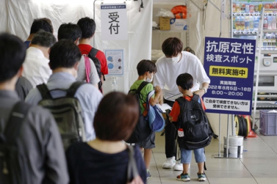 写真：新型コロナウイルス感染拡大を受け、ＪＲ新大阪駅に設置された臨時の無料検査場に並ぶ人たち＝５日午前
