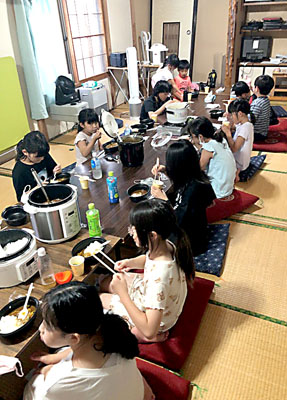 写真：お泊まり会で自分たちで調理した夕食を味わう子どもたち