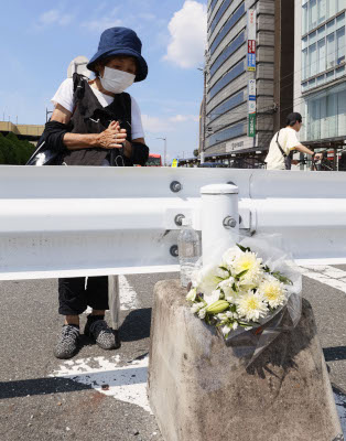 写真：安倍元首相が銃撃され死亡した事件から１カ月となり、現場近くで手を合わせる女性＝８日午後、奈良市