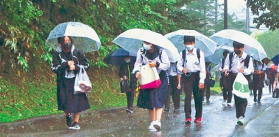 写真：雨の中、傘を差して元気に登校する生徒