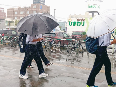写真：雨の中、傘をさして下校する生徒＝３１日午前１１時４０分ごろ、室蘭市東町