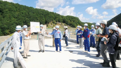 写真：報道陣に厚真ダムの工事の現状を説明する関係者