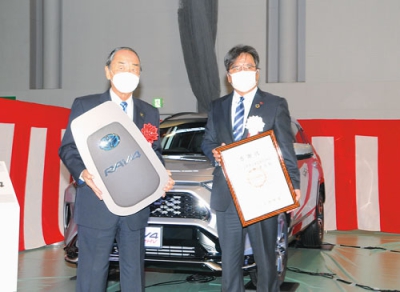 写真：寄贈した車の前で記念写真に納まる岩倉市長と北條社長（右）