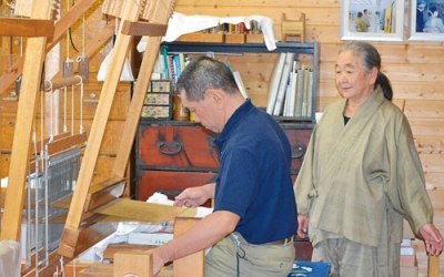 写真：木村みちよさん（右）と機織り道具を使う次男・亮さん