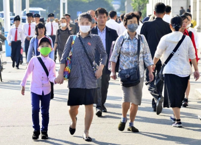写真：平壌駅周辺をマスク姿で歩く市民ら＝２２日（共同）