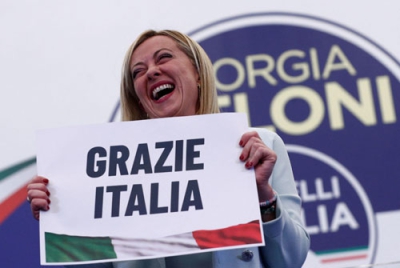 写真：「ありがとうイタリア」と書かれた紙を掲げる「イタリアの同胞」のメローニ党首＝２６日、ローマ（ロイター＝共同）