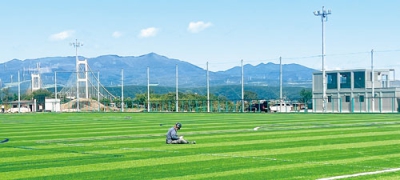 写真：ピッチに人工芝がお目見えした祝津公園サッカー場。右奥は新たに建てられたクラブハウス