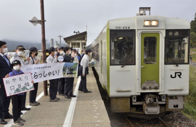 写真：１１年ぶりに全線再開したＪＲ只見線の只見駅で、列車の発車を見送る人たち＝１日午前、福島県只見町
