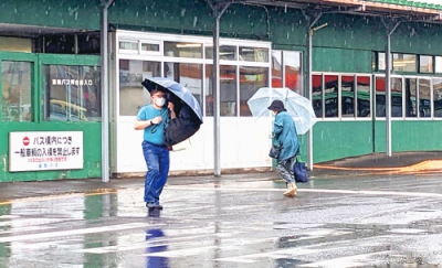 写真：傘を差し足早に歩く市民たち＝４日午前９時５０分ごろ、室蘭市東町ターミナル