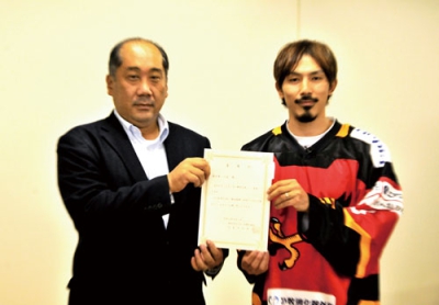 写真：委嘱状を手に記念写真に収まる佐々木選手（右）