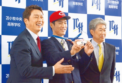 写真：新井監督（左）からドラフト会議ＩＤを受け取り笑顔を見せる斉藤（中央）