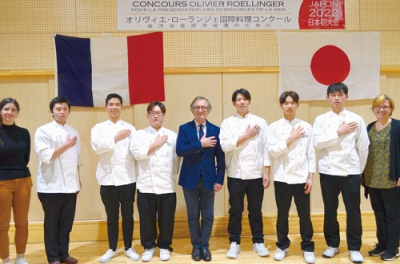 写真：日本初開催の料理コンクールで審査委員長を務めるオリヴィエ氏（中央）と出場する学生