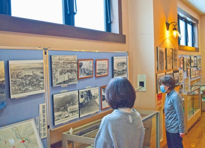 写真：昭和期の室蘭を撮った写真と出版物に見入る市民ら
