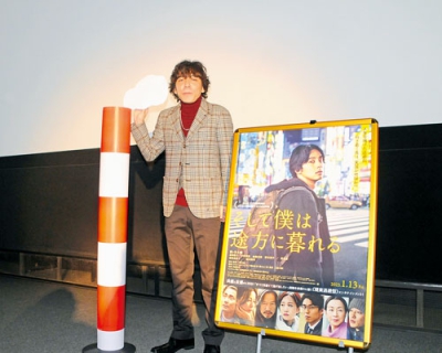 写真：映画にも登場する王子製紙の煙突と一緒に記念撮影に納まる三浦監督
