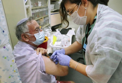 写真：エルサレムの診療所で新型コロナワクチン接種を受ける男性＝２０２１年８月（共同）