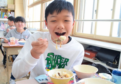 写真：のぼりべつ牛丼を笑顔で食べる児童