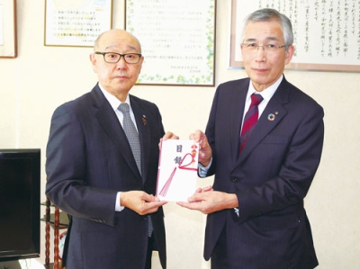 写真：竹中町長に目録を手渡す鈴木社長（右）