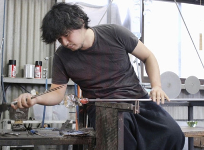 写真：再生ガラスを材料にしたグラスを制作する水口智貴さん＝２０２２年１２月、岡山県倉敷市
