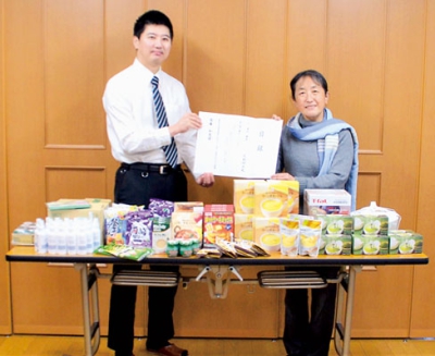 写真：食品などを寄贈した大津店長（左）と受け取ったＷＡＴの会の須藤代表
