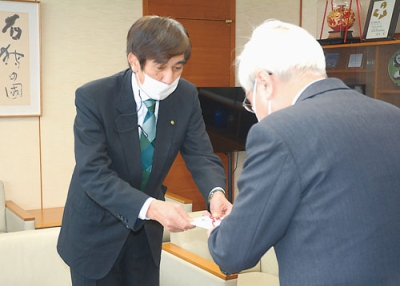 写真：菊谷市長に善意を手渡す栗林社長