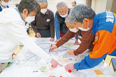 写真：ＤＩＧで地図に津波浸水区域を書き込む参加者たち