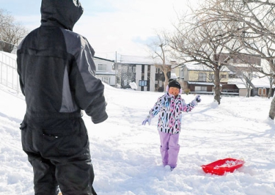 写真：公園で雪遊びを楽しむ親子＝午前１１時ごろ、室蘭市高砂町