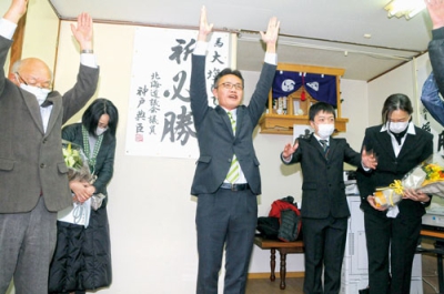 写真：バンザイして初当選を祝う大塩氏＝５日午後１０時半、白老町大町の選対事務所