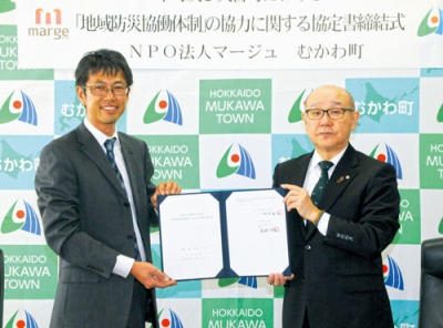 写真：協定書を手にする竹中町長（右）と岡松理事長