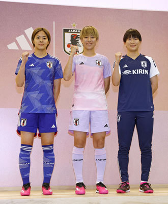 写真：サッカー女子Ｗ杯で日本代表が着用するアウェー用の新ユニホームを着てポーズをとる、植木理子（中央）。左はホーム用ユニホーム姿の小林里歌子、右は藤野あおば＝２３日、東京・国立競技場