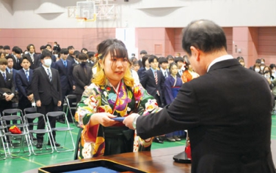 写真：空閑学長から学位記を受け取る卒業生